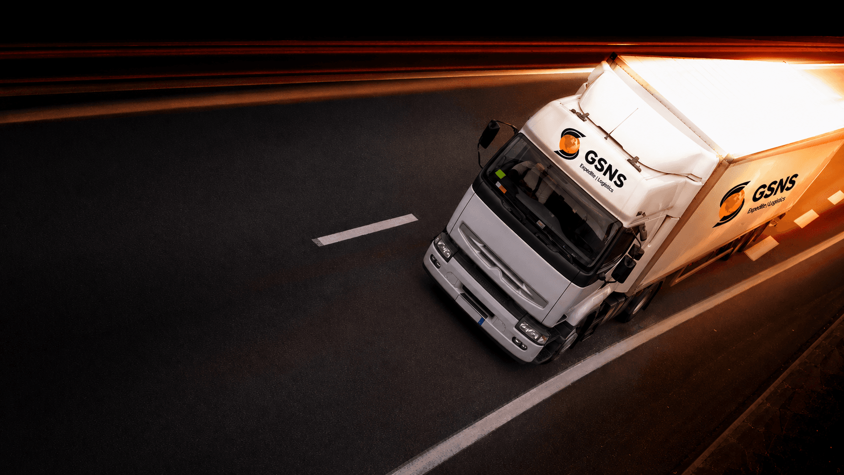 GSNS Expedite freight trailer on a night highway with motion-blur light streaks